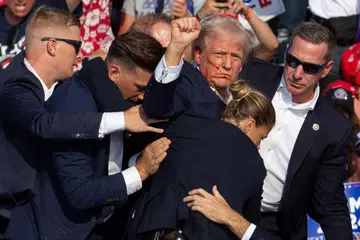 Bekas presiden Amerika Syarikat, Encik Donald Trump, dikelilingi ejen Perkhidmatan Rahsia selepas cubaan membunuhnya di Butler, Pennsylvania, pada 13 Julai 2024.