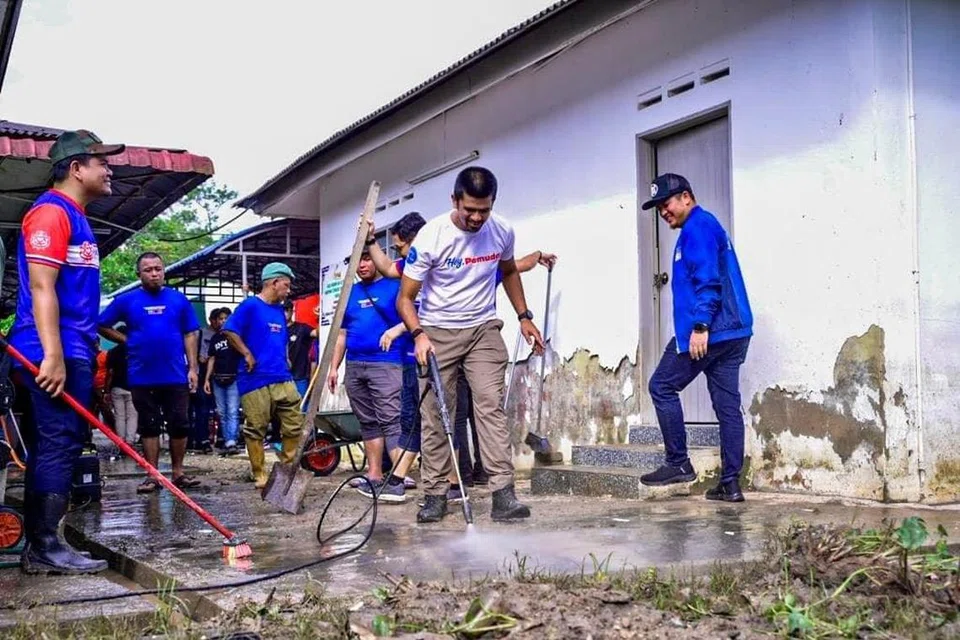 SUMBANG TENAGA: Petugas sukarelawan membantu membersihkan kediaman mangsa banjir di Johor yang diselaputi lumpur.