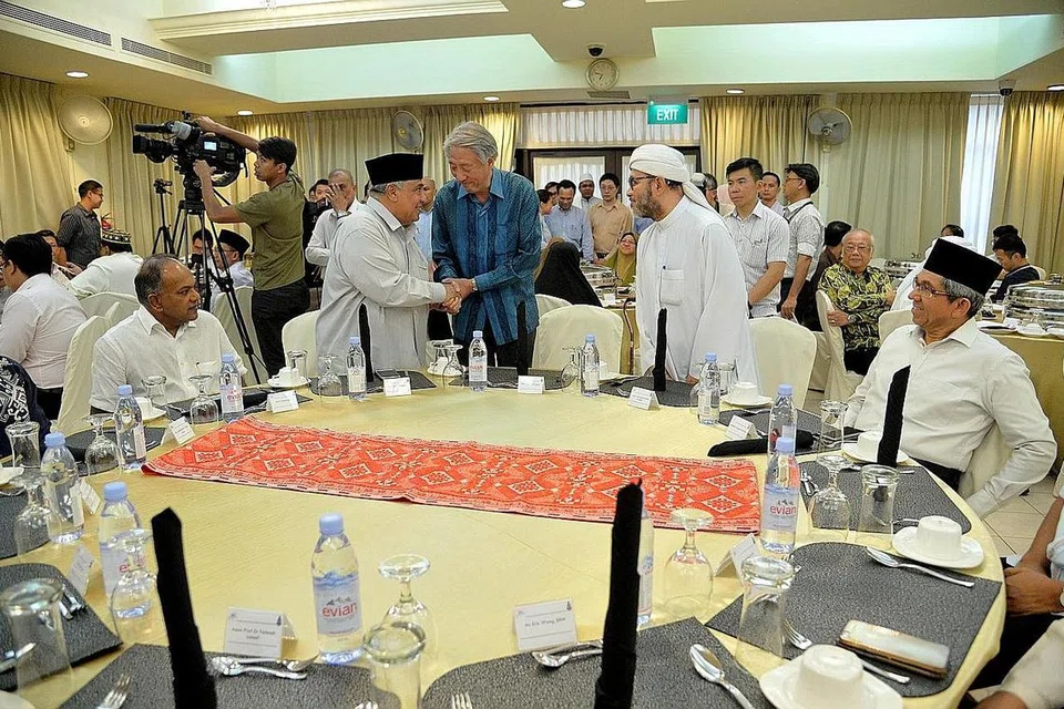 HARGAI SUMBANGAN RRG: Encik Teo (tengah) berjabat tangan dengan pengerusi bersama RRG Ustaz Ali Mohamed sebelum majlis iftar bermula di Masjid Khadijah semalam. Bersama mereka ialah (dari kiri) Encik Shanmugam, pengerusi bersama RRG Ustaz Hasbi Hassan dan Dr Yaacob. - Foto M.O. SALLEH
