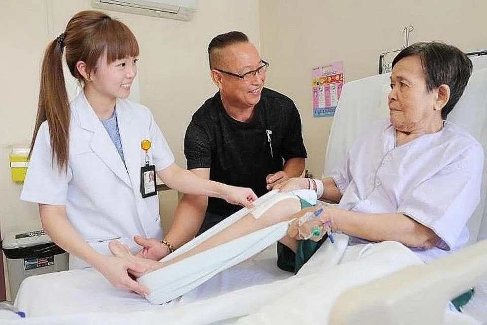 BERI SOKONGAN: (Dari kiri) Ahli fisioterapi kanan Hospital Tan Tock Seng, Cik Jaclyn Tan; sukarelawan Encik Lim Thiam Beng dan Cik Chong, seorang pesakit yang melalui pembedahan lutut. - Foto BH oleh JONATHAN CHOO