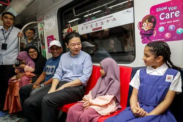 Perdana Menteri, Encik Lawrence Wong (tengah), berinteraksi dengan seorang kanak-kanak yang menaiki kereta api bersama keluarganya di Laluan Thomson-East Coast (TEL) Tahap 4 yang baru dibuka pada 21 Jun. 