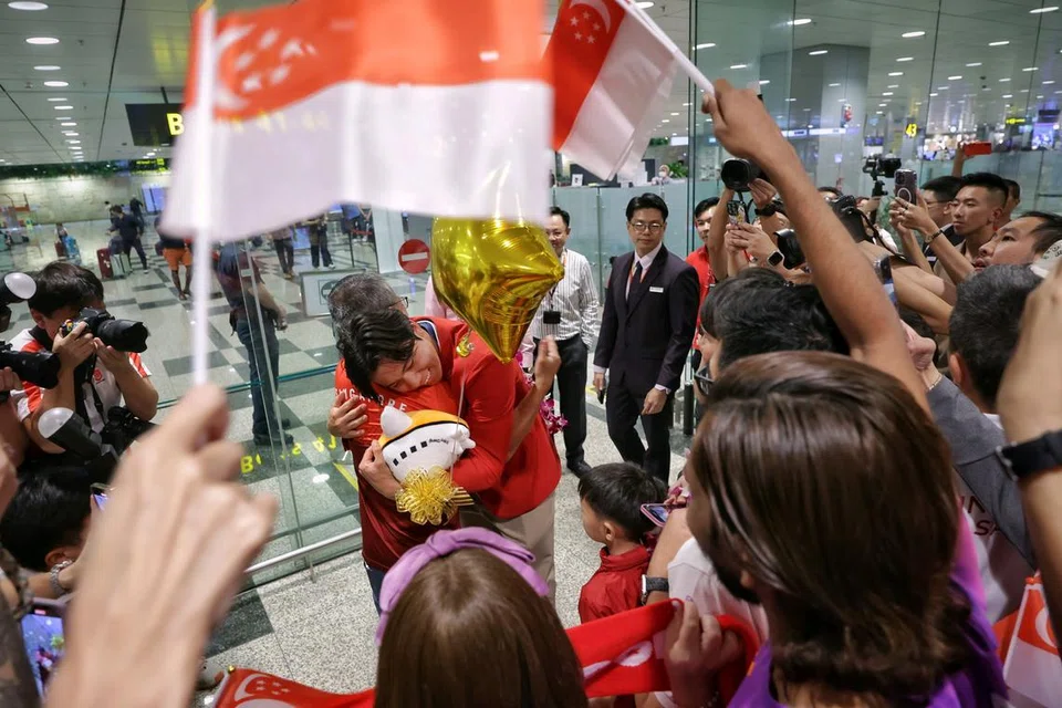 Maeder (kanan) mendapat pelukan dari Menteri Kebudayaan, Masyarakat dan Belia, Encik Edwin Tong setelah tiba di Terminal 3 Lapangan Terbang Changi dari Paris pada 13 Ogos.