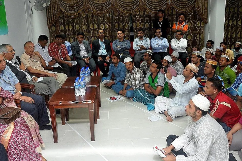 SESI DIALOG: Encik Md Mustafizur Rahman (memegang mikrofon) sempat menasihati dan mendengar maklum balas daripada para pekerja semasa lawatannya ke dormitori The Leo, di Kaki Bukit, kelmarin. Di kanan Encik Md Mustafizur ialah Encik Hawazi Daipi. - Foto KHALID BABA