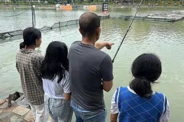 MENGERATKAN HUBUNGAN: Encik Haki bersama anaknya semasa program 'Memancing Bersama Ayah' semalam di D'Best Fishing, Kolam Pasir Ris. - Foto BAPA SEPANJANG HAYAT