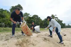 BERSIHKAN PANTAI: Encik Mohd Fahmi Aliman (kiri) bersama relawan Sharifah Sheikha Haroon Aljunied dan anaknya, Encik Daniyal Rashad Mohammad Yusri, mengutip sampah di pantai East Coast semasa kegiatan membersihkan pantai anjuran CDC South East pada Sabtu (17 Sep). - Foto BM oleh ALPHONSUS CHERN
