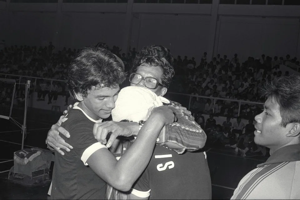 R. S. Selamat (berkaca mata), ketua jurulatih pasukan sepak takraw kebangsaan, memeluk para pemain muda pasukan sepak takraw Singapura (dari kiri) Shukor Shadik, Ahmad Tapri dan Rosli Tanjung - selepas pasukan itu menewaskan Malaysia untuk menjuarai Piala Ya’acob Mohamed di Kompleks Sukan Delta pada 27 Disember 1980.