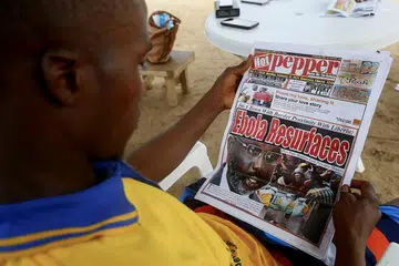 MUNCUL SEMULA: Seorang lelaki Liberia membaca laporan mengenai wabak Ebola yang melanda negara jiran, Guinea, dengan empat orang disahkan mati ekoran virus tersebut. - Foto EPA-EFE