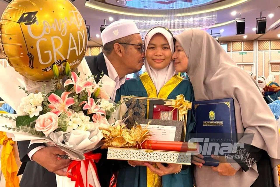DETIK MEMBANGGAKAN: Cik Izzah Zulkifli (tengah) bersama ibunya, Cik Sahidatina Zahari (kanan), dan bapanya, Encik Zulkifli Husain, 54