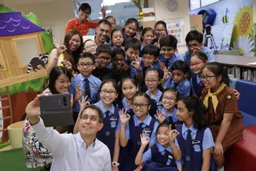 BERGAMBAR BERSAMA: Dr Faishal Ibrahim mengambil peluang bergambar bersama sekumpulan pelajar dan guru Sekolah Rendah Chongzheng semasa lawatannya ke sekolah itu untuk mempelajari tentang projek Nilai Dalam Tindakan (VIA) yang dijalankan dan berinteraksi bersama pelajar.