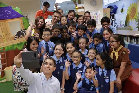 BERGAMBAR BERSAMA: Dr Faishal Ibrahim mengambil peluang bergambar bersama sekumpulan pelajar dan guru Sekolah Rendah Chongzheng semasa lawatannya ke sekolah itu untuk mempelajari tentang projek Nilai Dalam Tindakan (VIA) yang dijalankan dan berinteraksi bersama pelajar.