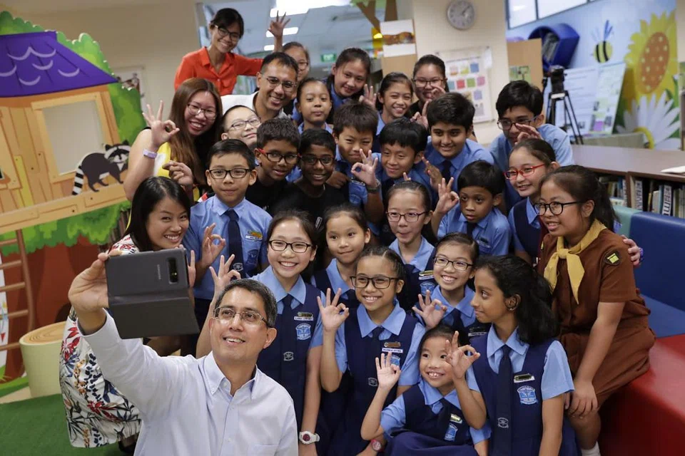 BERGAMBAR BERSAMA: Dr Faishal Ibrahim mengambil peluang bergambar bersama sekumpulan pelajar dan guru Sekolah Rendah Chongzheng semasa lawatannya ke sekolah itu untuk mempelajari tentang projek Nilai Dalam Tindakan (VIA) yang dijalankan dan berinteraksi bersama pelajar.