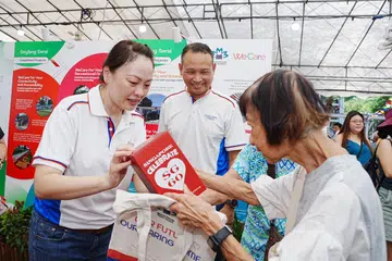 Mayor Majlis Pembangunan Masyarakat (CDC) South East, Encik Mohd Fahmi Aliman (tengah) perkenalkan pengarah pembangunan perniagaan, Cik Diana Pang (kiri), kepada penduduk semasa melancarkan Pelan Induk Lima Tahun Bandar Marine Parade pada 19 April.