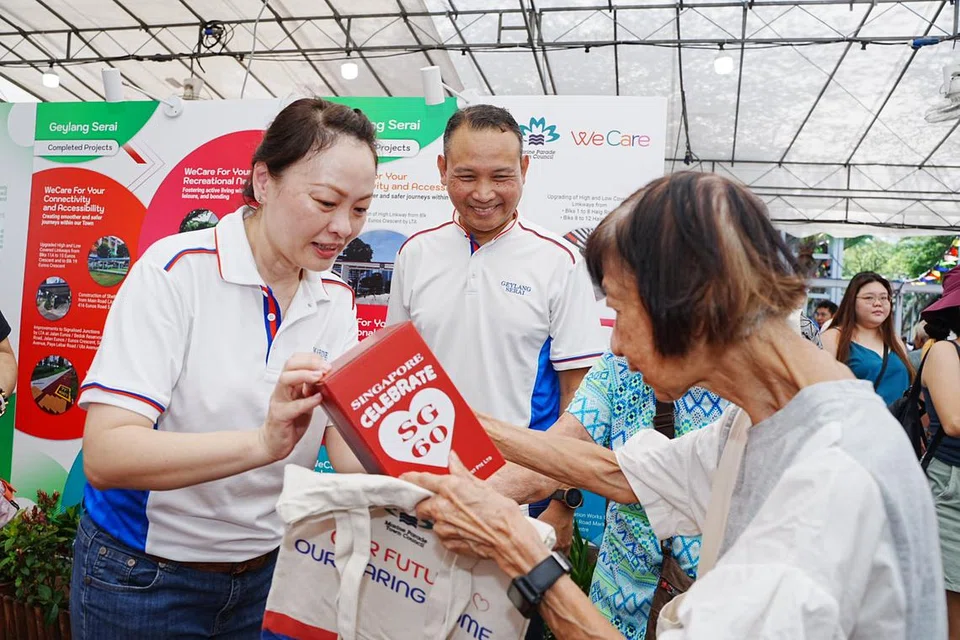 Mayor Majlis Pembangunan Masyarakat (CDC) South East, Encik Mohd Fahmi Aliman (tengah) perkenalkan pengarah pembangunan perniagaan, Cik Diana Pang (kiri), kepada penduduk semasa melancarkan Pelan Induk Lima Tahun Bandar Marine Parade pada 19 April.