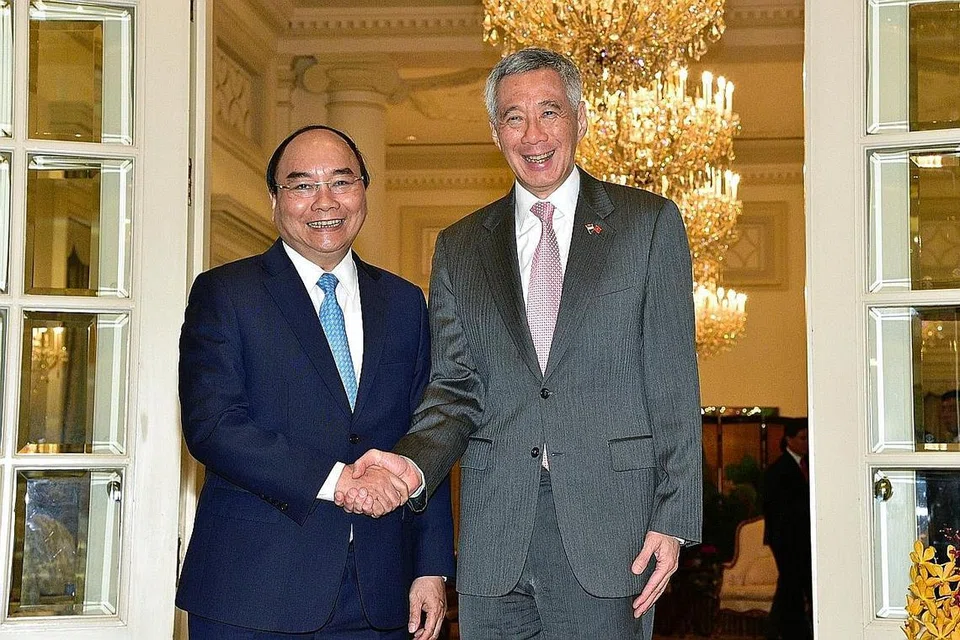 MENGUKUH HUBUNGAN: PM Lee dan Encik Phuc berjabat tangan, mencerminkan hubungan kukuh Singapura dan Vietnam sejak 45 tahun lalu. - Foto BH oleh DESMOND WEE
