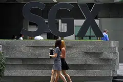 KENAIKAN DIJANGKAKAN: Dua wanita berjalan di depan bangunan Pusat SGX semalam. Indeks Straits Times (STI) naik 0.82 peratus atau 25.84 mata kepada 3163.27 pada sebelah petang semalam. - Foto THE STRAITS TIMES