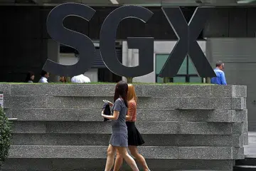 KENAIKAN DIJANGKAKAN: Dua wanita berjalan di depan bangunan Pusat SGX semalam. Indeks Straits Times (STI) naik 0.82 peratus atau 25.84 mata kepada 3163.27 pada sebelah petang semalam. - Foto THE STRAITS TIMES