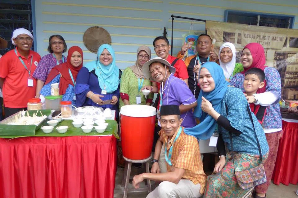 Dr Mohamad Maliki Osman (enam dari kiri) dirakam bersama sukarelawan semasa sambutan Hari Kebangsaan di Pulau Ubin pada 2017.