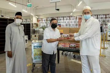 TIDAK KIRA AGAMA: Encik Raja (tengah) memberikan sekotak kurma kepada Encik Gamal (kanan) sebagai tanda sokongan Lembaga Endowmen Hindu kepada Muslim yang kini sedang menjalani ibadah puasa. Bersama mereka ialah imam Masjid Angullia, Imam Mohamed Sharfudeen Abdullah, di pengagihan kurma Masjid Angullia semalam. - Foto HINDU ENDOWMENTS BOARD