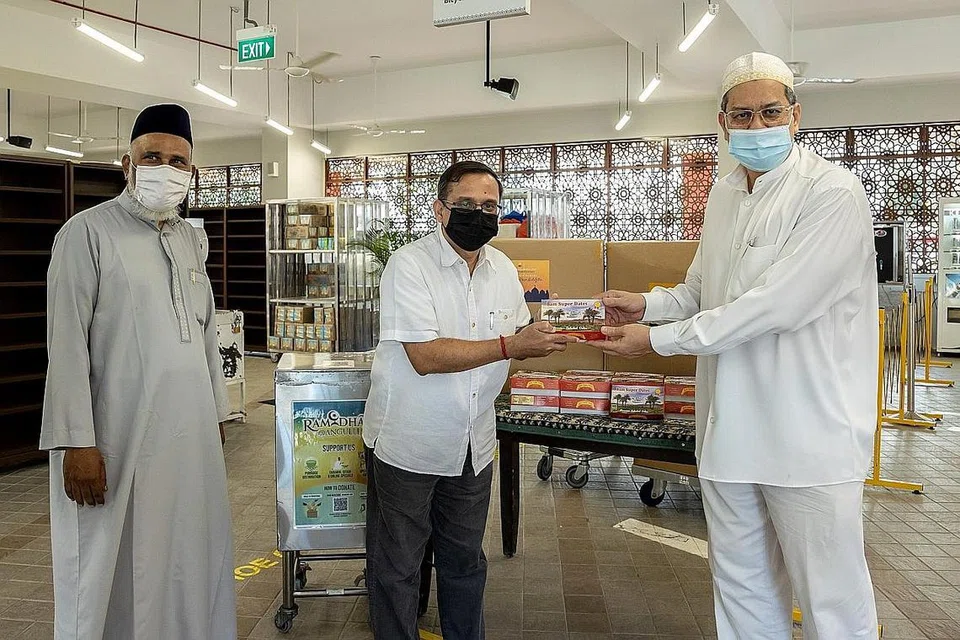 TIDAK KIRA AGAMA: Encik Raja (tengah) memberikan sekotak kurma kepada Encik Gamal (kanan) sebagai tanda sokongan Lembaga Endowmen Hindu kepada Muslim yang kini sedang menjalani ibadah puasa. Bersama mereka ialah imam Masjid Angullia, Imam Mohamed Sharfudeen Abdullah, di pengagihan kurma Masjid Angullia semalam. - Foto HINDU ENDOWMENTS BOARD