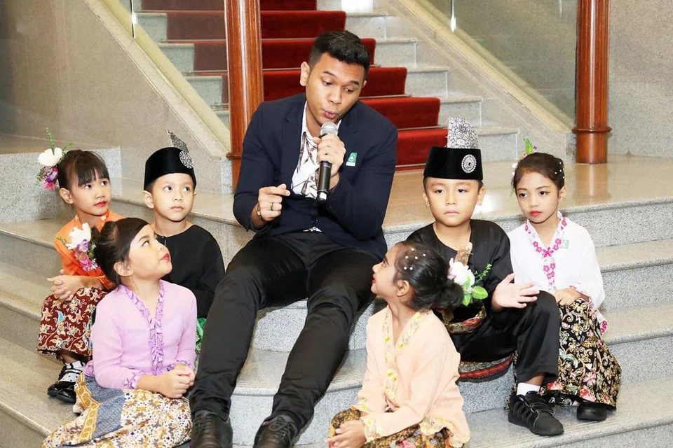 TARIKAN KANAK-KANAK: Wawan Husen menghiburkan kanak-kanak dalam usaha menggalak penggunaan Bahasa Melayu di kalangan si kecil.