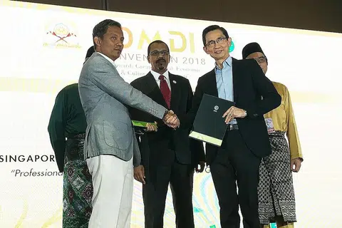 BANGUNKAN KEUPAYAAN HALAL: Pengarah Eksekutif SIM, Encik Ronald Tan (kanan) berjabat tangan dengan Encik Zuraimi selepas memeterai MOU dalam Konvensyen Dunia Melayu Dunia Islam (DMDI) ke-19 anjuran Jamiyah baru-baru ini. - Foto SIM
