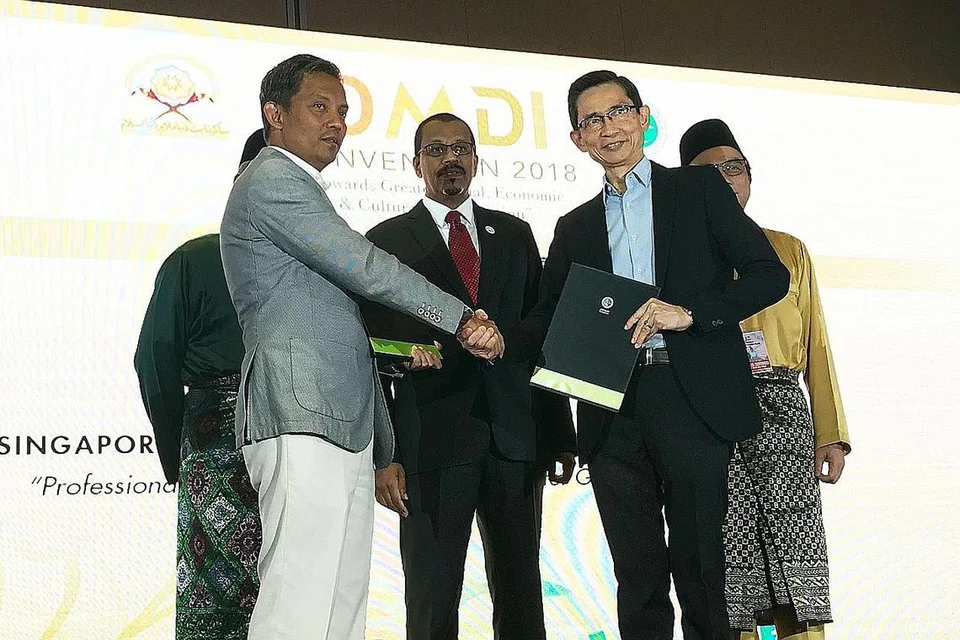BANGUNKAN KEUPAYAAN HALAL: Pengarah Eksekutif SIM, Encik Ronald Tan (kanan) berjabat tangan dengan Encik Zuraimi selepas memeterai MOU dalam Konvensyen Dunia Melayu Dunia Islam (DMDI) ke-19 anjuran Jamiyah baru-baru ini. - Foto SIM