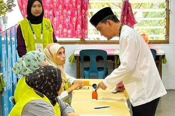Menteri Besar Johor, Datuk Onn Hafiz Ghazi, mencelup jari telunjuk kiri ke dalam botol dakwat kekal bagi menandakan beliau telah selesai membuang undi.