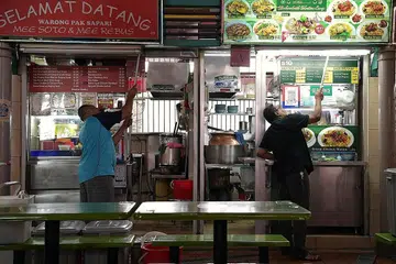 PERTINGKAT USAHA PEMBERSIHAN: Penjaja di pusat penjaja Adam Road telah mempertingkatkan usaha mereka untuk membersihkan gerai dan pusat makan itu demi memastikan kebersihan dan mendapatkan kepercayaan pelanggan susulan penularan Covid-19. - Foto BH oleh KUA CHEE SIONG