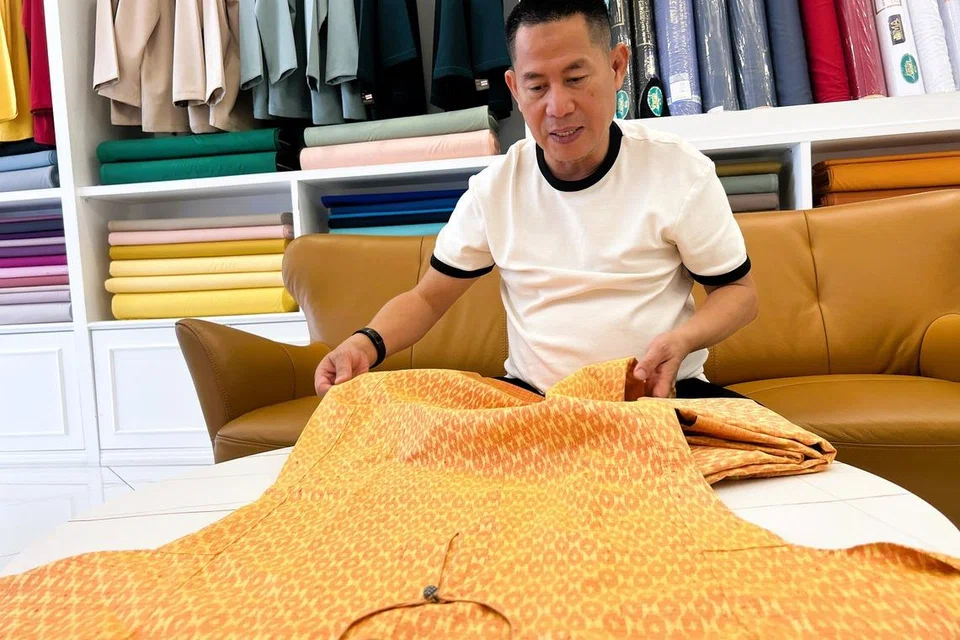 Pemilik kedai jahitan jenama Teluk Belanga, Encik Jamil Sukaimi, menunjukkan baju kurung yang menggunakan teknik jahitan tulang belut di bahagian leher.