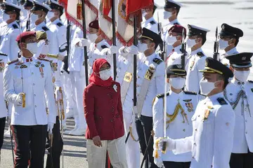 HARAP PAPAR KETABAHAN S'PURA: Presiden Halimah Yacob memeriksa perbarisan di istiadat perbarisan Hari Kebangsaan pagi semalam bagi sambutan ulang tahun ke-56 Singapura. - Foto BH oleh CHONG JUN LIANG