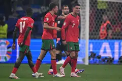 Pemain Portugal, Cristiano Ronaldo (kanan), menunjukkan reaksi selepas gagal sempurnakan sepakan penalti dalam perlawanan menentang Slovenia di Frankfurt. 