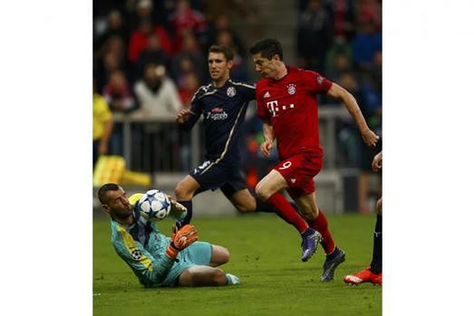 SAMBAR PELUANG: Wira hatrik Bayern, Robert Lewandowski (jersi merah), cuba menyambar bola daripada penjaga gawang Dinamo, Eduardo. - Foto REUTERS