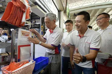 LEBIH HIJAU DAN MAMPAN: Encik Lee Hsien Loong (kiri) dan Encik Yip Hon Weng (dua dari kanan) mengunjungi Pasar dan Pusat Makanan 628 Ang Mo Kio semalam di mana gerakan 'Katakan Tidak Kepada Barang Pakai Buang' dilancarkan semalam. Kunjungan itu adalah sebahagian daripada kegiatan jejak eko Tolak, Kurangkan, Guna Semula dan Kitar Semula yang diadakan. - Foto BH oleh NG SOR LUAN