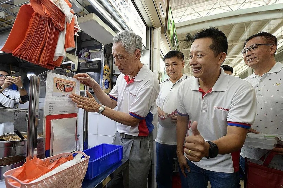 LEBIH HIJAU DAN MAMPAN: Encik Lee Hsien Loong (kiri) dan Encik Yip Hon Weng (dua dari kanan) mengunjungi Pasar dan Pusat Makanan 628 Ang Mo Kio semalam di mana gerakan 'Katakan Tidak Kepada Barang Pakai Buang' dilancarkan semalam. Kunjungan itu adalah sebahagian daripada kegiatan jejak eko Tolak, Kurangkan, Guna Semula dan Kitar Semula yang diadakan. - Foto BH oleh NG SOR LUAN