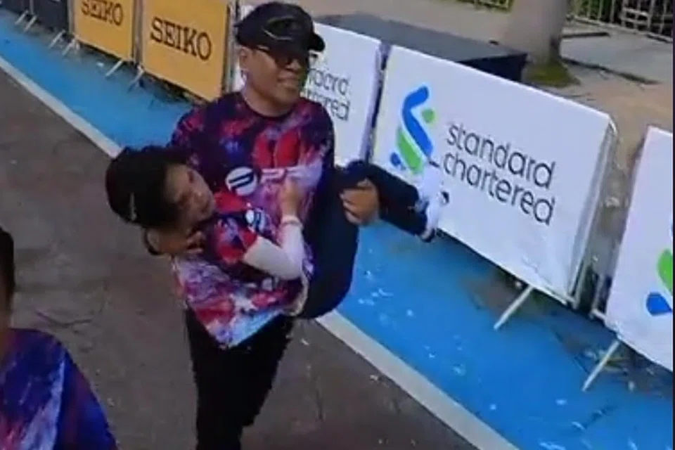 TAMATKAN LARIAN: Encik Wira Sudepja Rabu menggendong anaknya, Nur Wadihan Wira Sudepja, ke garisan penamat bagi kategori larian 21 kilometer Maraton Standard Chartered di Kuala Lumpur pada Ahad.