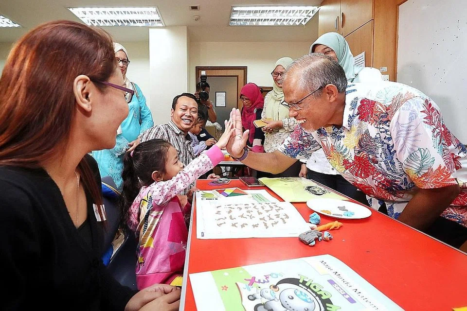 MEMPERSIAP SI CILIK: Encik Masagos Zulkifli (kanan) bermesra dengan Nayli Yusyairah Muhd Faizal, lima tahun, sambil disaksikan ibu bapanya, Cik Normaya Johari (kiri) dan Encik Muhd Faizal Jamil (tiga dari kiri) yang menyertai Program KelasMateMatika (KMM) iaitu inisiatif pertama di bawah kerjasama badan M Kuasa Tiga (M³) - Majlis Penyelaras Kumpulan Kegiatan Melayu Persatuan Rakyat (Mesra), Yayasan Mendaki dan Majlis Ugama Islam Singapura (Muis). - Foto BH oleh GAVIN FOO