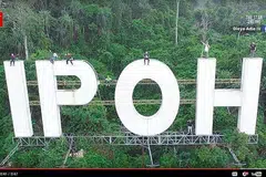 Lapan anak muda, termasuk tiga wanita, memasang buaian pada tanda gergasi 'IPOH' dan mengambil gambar menggunakan dron. Mereka kelihatan tidak memakai alat keselamatan. 