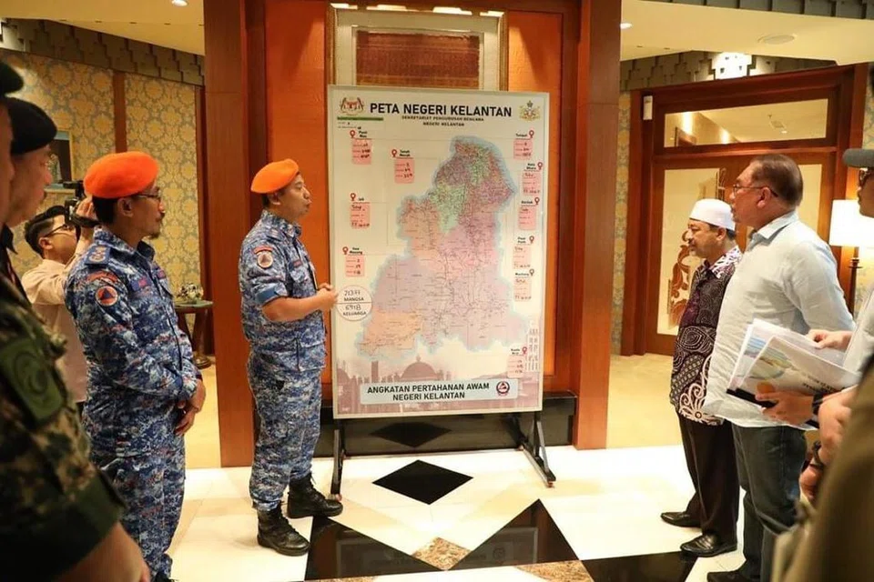 TAKLIMAT BANJIR: Pengarah Angkatan Pertahanan Awam Kelantan, Kolonel (PA) Encik Mohd Adzhar Mujab (dua dari kiri) menyampaikan taklimat berkait situasi banjir di Kelantan kepada Perdana Menteri, Datuk Seri Anwar Ibrahim (kanan) dan Menteri Besar Kelantan, Datuk Mohd Nassuruddin Daud (dua dari kanan) pada 28 Disember. 