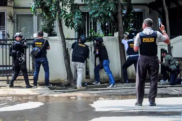 BERSIAP HADAPI PENYERANG: Pegawai polis dilihat dekat pejabat pemerintah tempatan menyusuli kejadian letupan di Bandung, Jawa Barat, Indonesia, semalam. Polis Indonesia menembak mati lelaki yang disyaki meletupkan bom itu. - Foto REUTERS
