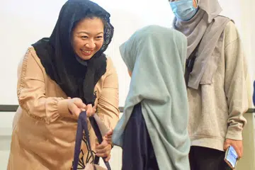 TERIMA HADIAH: Seorang kanak-kanak perempuan menerima beg yang mengandungi beg sekolah, kotak pensel, buku nota dan fail daripada Anggota Parlimen (GRC Pasir Ris), Cik Yeo Wan Ling, dalam satu acara ‘Kembali Ke Sekolah’ bagi kanak-kanak keluarga berpendapatan rendah di Masjid Al-Islah di Punggol pagi Ahad.