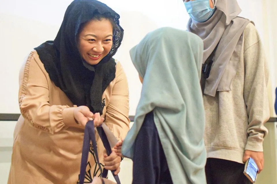 TERIMA HADIAH: Seorang kanak-kanak perempuan menerima beg yang mengandungi beg sekolah, kotak pensel, buku nota dan fail daripada Anggota Parlimen (GRC Pasir Ris), Cik Yeo Wan Ling, dalam satu acara ‘Kembali Ke Sekolah’ bagi kanak-kanak keluarga berpendapatan rendah di Masjid Al-Islah di Punggol pagi Ahad.