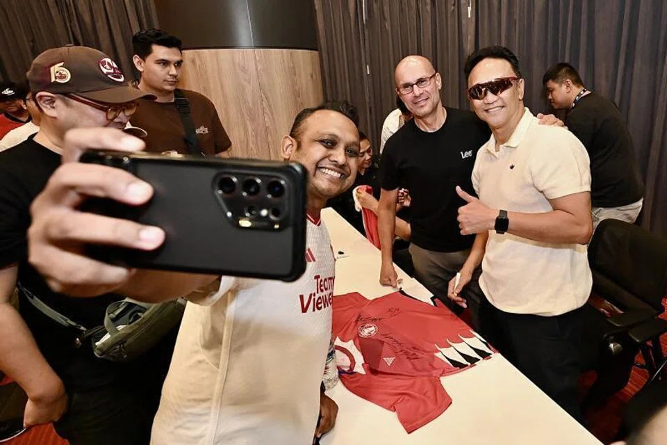 Seorang peminat dirakam mengambil swafoto bersama Fandi Ahmad (kanan) dan Abbas Saad di sampingnya. Kededuanya merupakan pemain nasional bagi pasukan Lions, yang menjulang Piala Malaysia 1994.