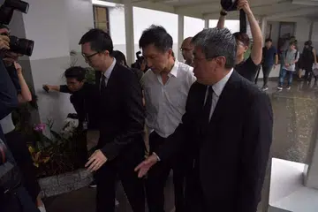 MASUK PENJARA: Pengasas Gereja City Harvest, Kong Hee, diapit dua lelaki tiba bangunan Mahkamah Negara kira-kira 8.30 pagi tadi untuk menyerah diri bagi menjalani hukuman penjara selama 3½ tahun. - Foto THE STRAITS TIMES.