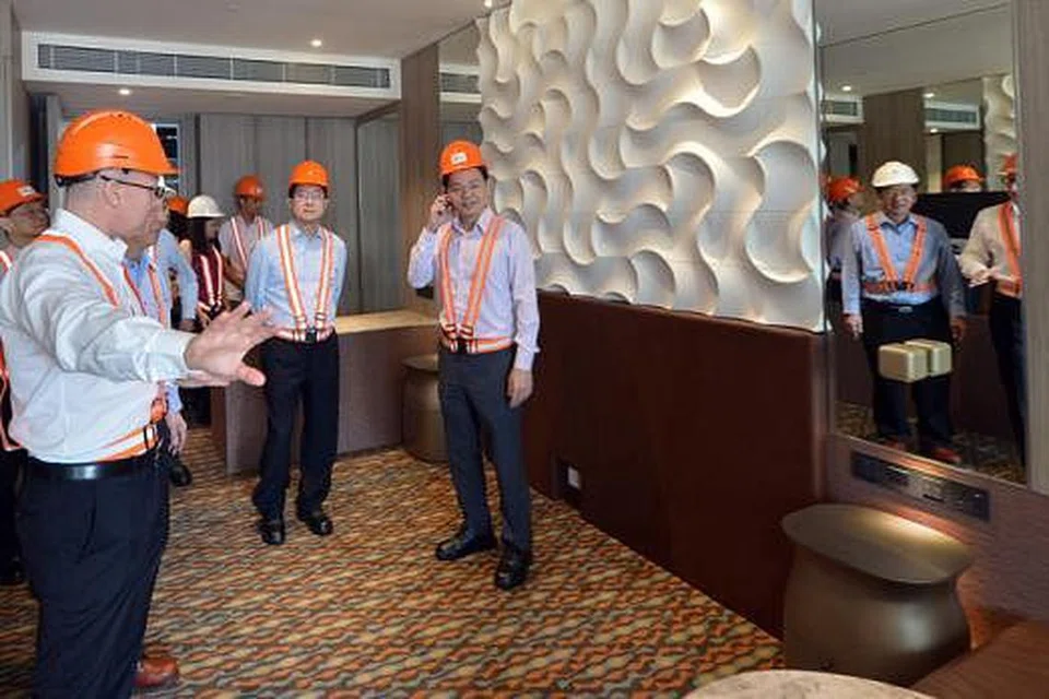 BILIK HOTEL PASANG SIAP: Encik Wong (kanan) memeriksa ruang di bilik pasang siap dalam peluasan Hotel Crowne Plaza Changi Airport semasa mengunjungi tapak binaan itu semalam. - Foto THE STRAITS TIMES
