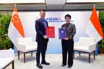 Setiausaha Tetap Kementerian Perhubungan dan Penerangan (MCI), Encik Joseph Leong (kiri), dan Setiausaha Agung Kementerian Komunikasi dan Informatika Indonesia (Kominfo), Cik Mira Tayyiba, bertukar salinan memorandum persefahaman (MOU) mengenai Kerjasama Transformasi Digital pada 1 Februari, di luar Mesyuarat Menteri-Menteri Digital Asean.