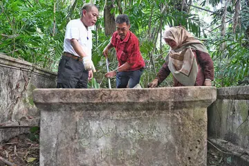 SEDIH LIHAT KEADAAN KUBUR TERBIAR: Cik Rafeah bersama suaminya, Muhd Mazlan Abdullah (kiri) dan sepupunya, Encik Sharif Mohd Arifin, kembali ke tapak perkuburan Marang pada 7 September lalu untuk membersihkan kubur-kubur yang telah lama diabaikan itu. - Foto BM oleh KHALIB BABA