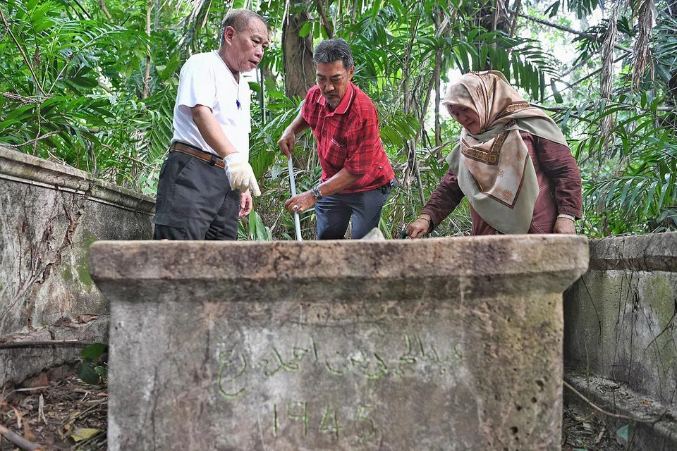 SEDIH LIHAT KEADAAN KUBUR TERBIAR: Cik Rafeah bersama suaminya, Muhd Mazlan Abdullah (kiri) dan sepupunya, Encik Sharif Mohd Arifin, kembali ke tapak perkuburan Marang pada 7 September lalu untuk membersihkan kubur-kubur yang telah lama diabaikan itu. - Foto BM oleh KHALIB BABA