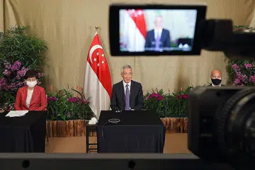 BERI UCAPAN: Perdana Menteri Lee Hsien Loong (tengah) menyertai Sidang Kemuncak Pemimpin mengenai Iklim yang dijalankan secara maya. Bersama beliau ialah Menteri Kemampanan dan Sekitaran Cik Grace Fu (paling kiri) dan Ketua Perunding Perubahan Iklim Singapura, Encik Joseph Teo. - Foto MCI