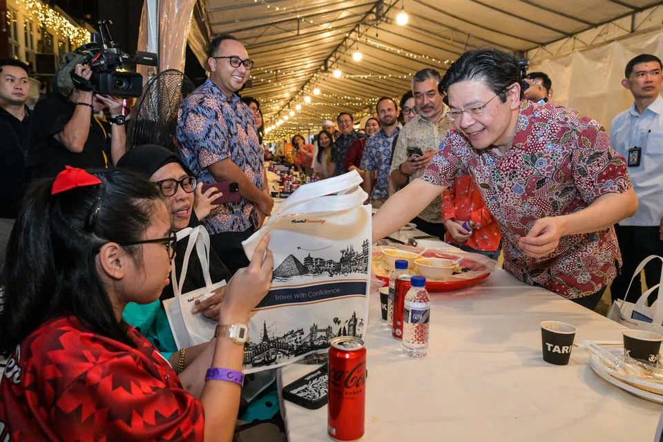 Encik Lawrence Wong menyampaikan sumbangan beg cenderahati kepada para penerima manfaat selepas selesai berbuka di majlis iftar beramai-ramai di Kampong Gelam.