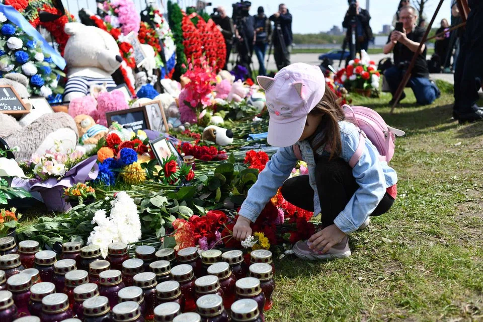 Fail foto menunjukkan seorang kanak-kanak meletakkan sejambak bunga di acara memperingati 150 mangsa yang maut dalam serangan pengganas ke atas Dewan Konsert Bandar Crocus, Russia, pada 30 April. 